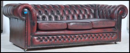 An antique style oxblood red leather Chesterfield sofa settee having buttoned back leather