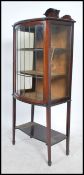 An Edwardian mahogany inlaid bow front display cabinet raised on square tapered legs with leaded