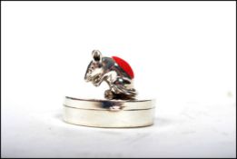 An unusual 20th century silver pill box of shaped form adorned with a mouse pin cushion to the