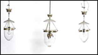 A group of three gilt brass framed light ceiling lanterns, the domed glass shade with single light