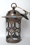 A 20th century Arts & Crafts revival copper lantern. Of cylindrical pierced form with hat top and