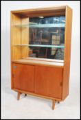 A 1960's teak open window display bookcase cabinet having a mirror back above a cupboard with