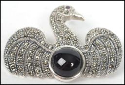 A ladies silver and marcasite  and onyx brooch in the form of a swan having a pin to verso