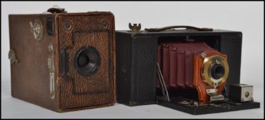 Early 20th century Ensign box camera together with a Kodak Brownie red leather bellows camera.