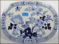 An 18th / 19th century Masons blue and white meat straining ceramic plate, decorated in a Asiatic