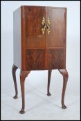 A 1940's Art Deco good walnut bow front cocktail cabinet raised on cabriole legs with mirror lined