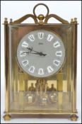 A 20th century glass cased mantle clock with columned front faceted hands and a roman numeral