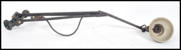A vintage mid 20th century industrial bench mounted anglepoise style adjustable work light having