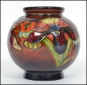 A mid century Walter Moorcroft globular ceramic vase painted and tube lined with flowers. The