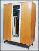 An early oak E Gomme / G-plan mirrored wardrobe with the white painted middle section raised on