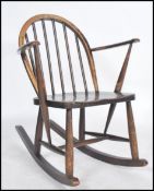 A mid 20th century Ercol rocking chair having cc utility mark raised on box rockers with rail