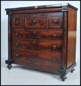 A large Victorian mahogany Scottish chest of drawers being raised on turned legs with column