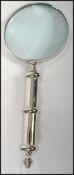 A contemporary and decorative good large desk top magnifying glass of brushed steel form and large