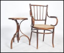 An early 20th century bentwood armchair in the manner of Thonet with a cane rush seat pad together