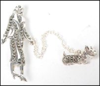 A silver Art Deco style brooch in the form a lady walking her dog having a pin set to verso