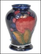 A 20th century William Moorcroft tubelined baluster vase decorated in the iconic pomegranate and