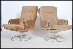A pair of Mid Century retro Danish inspired woollen swivel easy lounge chairs, having tubular chrome