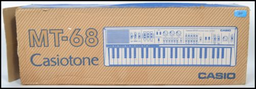 A vintage Casio Casiotone MT-68 electric portable piano complete in original box. Measurements: 7 cm
