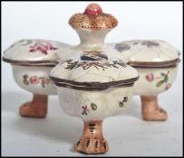 A 19th century Continental Majolica table cruet / salts, raised on tripod pad paw feet with lidded