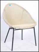 An unusual sputnik atomic style Lloyd Loom chair in white raised on ebonized tubular legs.