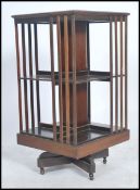 An Edwardian mahogany revolving bookcase having slatted sectional body raised on swivel column