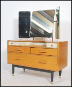 An early oak E Gomme / G-plan dressing table raised on ebonised turned legs with drawers and