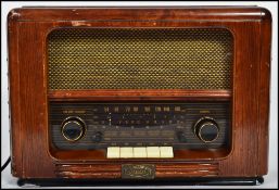 A vintage style reproduction electrical valve wooden cased radio with buttons and dials to front.