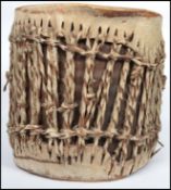 A vintage 20th century African tribal animal hide and hair drum with skin top and bottom stretched