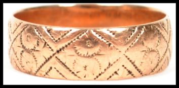 A 9ct hallmarked gold band ring of usual form with chase decoration, weighing 3.3g and