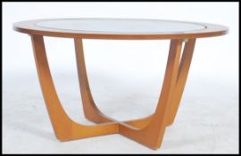 A vintage mid 20th century teak wood circular atomic coffee table fitted with a drop centre glass