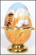 A Moorcroft painted enamel on copper trinket box in the form of an egg, decorated with chickens,