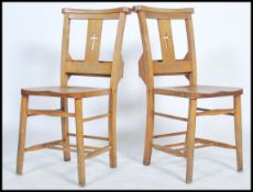 A pair of early to mid 20th century elm and beechwood chapel chairs with hymn book receptacles and