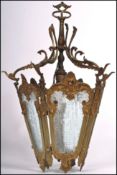 A vintage 20th century ornate gilt brass rococo style hall lantern with five glass panels.