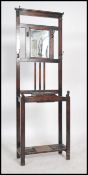 A 1920's oak hallstand having a central glove box with upright back having hooks and mirror glass to