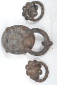 An early 20th century cast iron lion mask door knocker along with a pair of smaller floral door