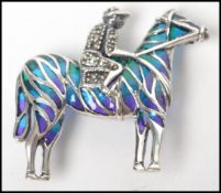 A ladies silver and plique a jour adorned brooch / pendant in the form of a jockey and rider - horse