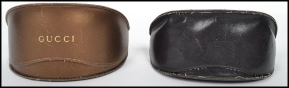 Two pairs of vintage Gucci sunglasses in original leather boxes with Gucci lettering to front.