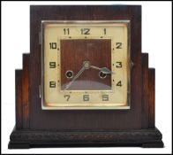 A 1930's Art Deco mantel clock set within an oak square case with silvered chapter ring and inset