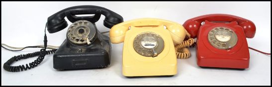 A group of three retro 20th century ring dial telephones, one red, one cream and one of black