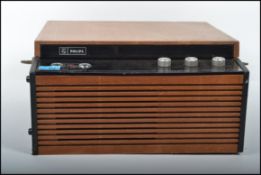 A vintage retro 20th century record player by Philips set in a two tone case with black glass and