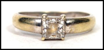 A hallmarked 9ct white gold ring ring having a central princess cut CZ stone. Weighs three grams and