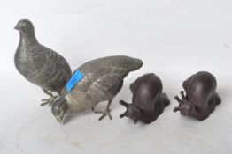 A pair of silver plated birds along with a pair of cast iron snails with a bronze effect finish.