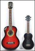 Two vintage miniature guitars to include a Takamin having a shaped flambe body and a four string
