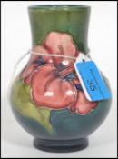 A Moorcroft baluster vase tube lined and decorated in the hibiscus pattern on a green and blue