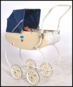 A vintage white coloured toy pram together with two retro children's dolls.