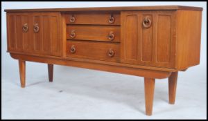 A 1970s Vintage teak wood beautillity sideboard, the drawers flanked by cupboards having loop