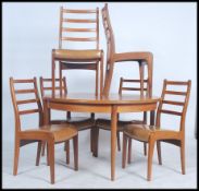 A 1970s G-plan teak round table with six teak ladder back dining chairs with unusual G-plan
