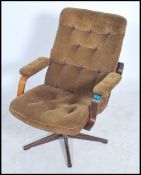 A 1970's brown corduroy swivel easy lounge armchair raised on  5 star point base and column.