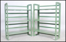 A pair of 20th century painted shelves having fixed central shelves with slatted sides ( see