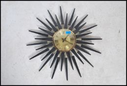 A 20th Century star burst wall clock inspired by George Nelson, black ebonized isosceles triangle